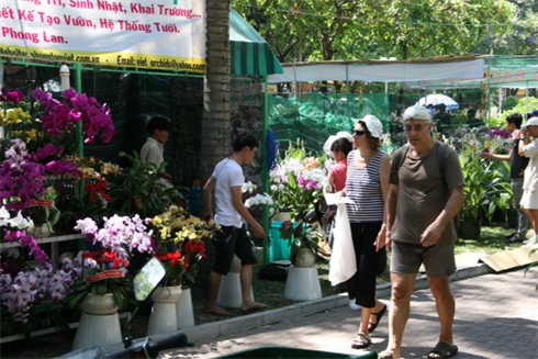 Les touristes visitent les stands du marché aux fleurs au parc du 23 septembre. Photo : Minh Thu/CVN 