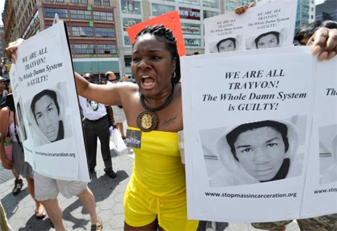 Une femme manifeste à New York en tenant à la main des portraits de Trayvon Martin, après l’acquittement de George Zimmerman. Photo : AFP/VNA/CVN