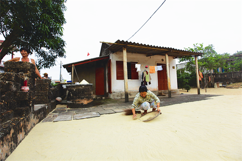 Maison entourée d’un jardin de sable stérile.