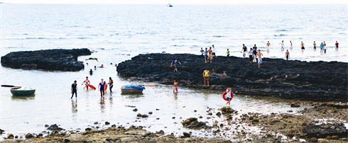 Au milieu des blocs de lave refroidie, la mer se retire.    