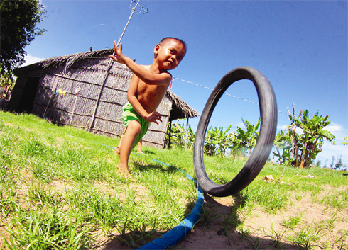 Un enfant joue près d’une maison nouvellement installée suite à un glissement de terrain qui a ravagé une partie du hameau de Tân Thi, commune de Thanh Hai, district de Thanh Phu, province de Bên Tre.